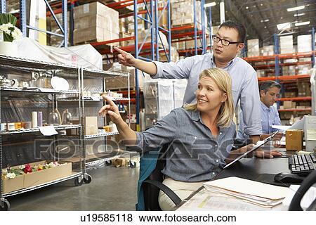 Business Colleagues Working At Desk In Warehouse View Large Photo Image Stock Photo - Business Colleagues Working At Desk In Warehouse. Fotosearch