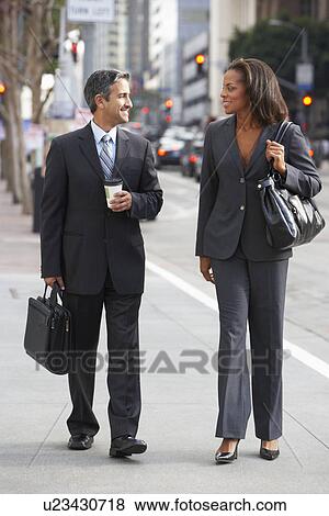 Stock Photo - Businessman And Businesswoman In Street With Takeaway Coffee. Fotosearch