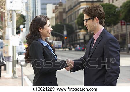 Stock Photo - Businessman And Businesswoman Shaking Hands In Street. Fotosearch
