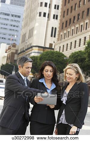 Businessman And Businesswomen Using Digital Tablet Outside View Large Photo Image Stock Photo - Businessman And Businesswomen Using Digital Tablet Outside. Fotosearch
