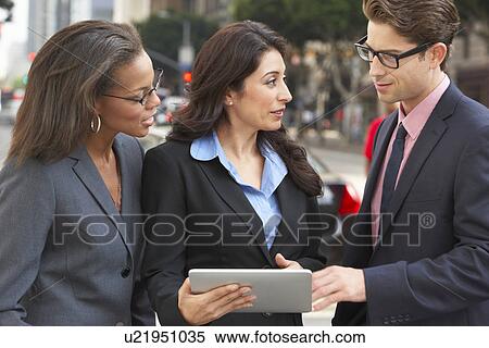 Stock Photography - Businessman And Businesswomen Using Digital Tablet Outside. Fotosearch