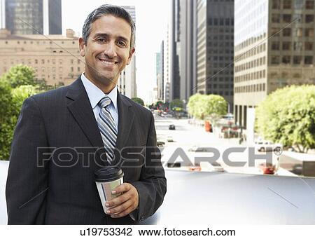 Stock Image - Businessman Drinking Takeaway Coffee Outside Office. Fotosearch