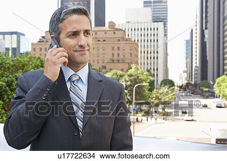 Picture - Businessman Outside Office On Mobile Phone. Fotosearch