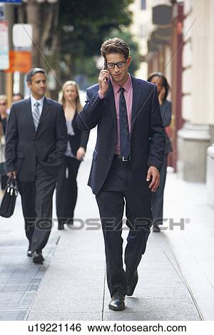 Stock Photograph - Businessman Outside Office On Mobile Phone. Fotosearch