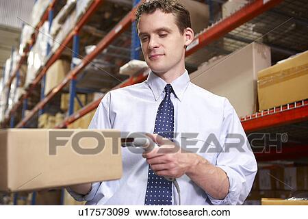 Businessman Scanning Package In Warehouse View Large Photo Image Stock Photo - Businessman Scanning Package In Warehouse. Fotosearch