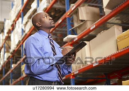 Picture - Businessman With Clipboard In Warehouse. Fotosearch