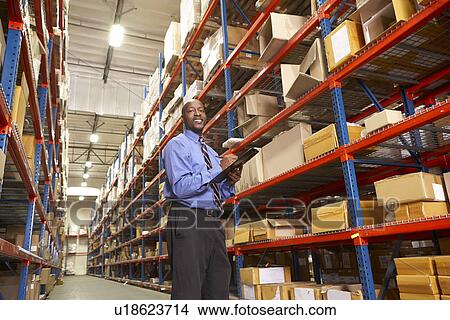 Picture - Businessman With Clipboard In Warehouse. Fotosearch