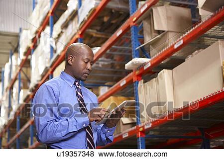 Businessman With Digital Tablet In Warehouse View Large Photo Image Stock Photo - Businessman With Digital Tablet In Warehouse. Fotosearch