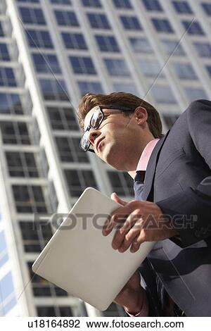Businessman Working On Tablet Computer Outside Office View Large Photo Image Stock Image - Businessman Working On Tablet Computer Outside Office. Fotosearch