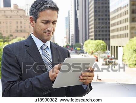 Businessman Working On Tablet Computer Outside Office View Large Photo Image Stock Image - Businessman Working On Tablet Computer Outside Office. Fotosearch