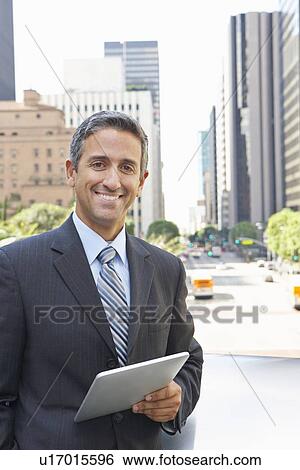 Businessman Working On Tablet Computer Outside Office View Large Photo Image Stock Photograph - Businessman Working On Tablet Computer Outside Office. Fotosearch