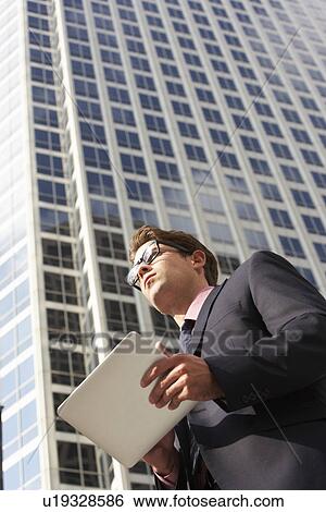 Businessman Working On Tablet Computer Outside Office View Large Photo Image Stock Photograph - Businessman Working On Tablet Computer Outside Office. Fotosearch