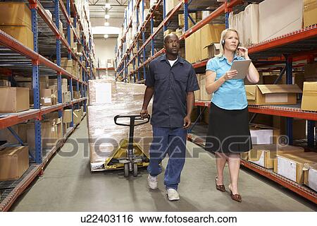 Businesswoman And Male Worker In Distribution Warehouse View Large Photo Image Stock Photograph - Businesswoman And Male Worker In Distribution Warehouse. Fotosearch