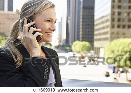 Stock Photo - Businesswoman Outside Office On Mobile Phone. Fotosearch