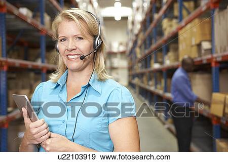 Businesswoman Using Headset In Distribution Warehouse View Large Photo Image Stock Photo - Businesswoman Using Headset In Distribution Warehouse. Fotosearch