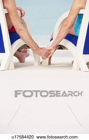 Close Up Of Senior Couple Holding Hands Beach In Chairs View Large Photo Image Stock Image - Close Up Of Senior Couple Holding Hands Beach In Chairs. Fotosearch