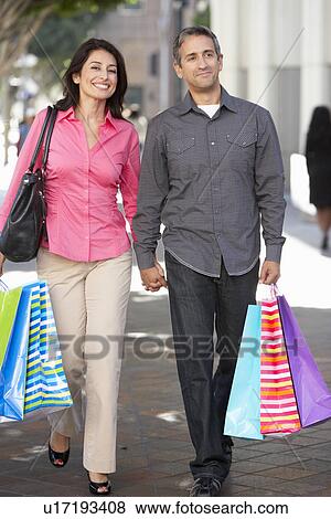 Stock Photo - Couple Carrying Shopping Bags On City Street. Fotosearch