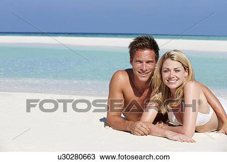 Stock Image - Couple Enjoying Beach Holiday. Fotosearch