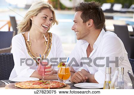 Stock Photography - Couple Enjoying Meal In Outdoor Restaurant. Fotosearch