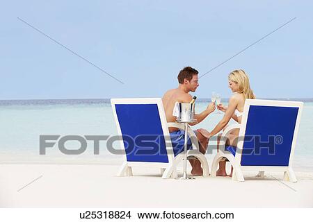 Couple On Beach Relaxing In Chairs And Drinking Chapagne View Large Photo Image Picture - Couple On Beach Relaxing In Chairs And Drinking Chapagne. Fotosearch