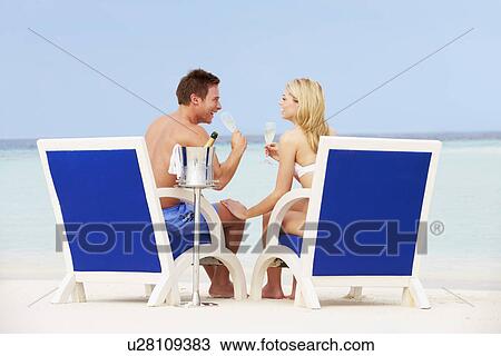 Couple On Beach Relaxing In Chairs And Drinking Chapagne View Large Photo Image Stock Image - Couple On Beach Relaxing In Chairs And Drinking Chapagne. Fotosearch