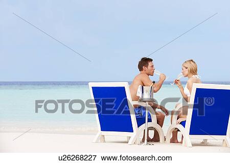 Couple On Beach Relaxing In Chairs And Drinking Chapagne View Large Photo Image Stock Photo - Couple On Beach Relaxing In Chairs And Drinking Chapagne. Fotosearch