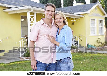 Stock Photography - Couple Standing Outside Suburban Home. Fotosearch