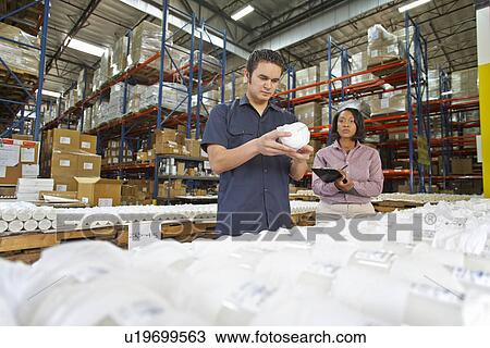 Stock Image - Factory Worker And Manager Checking Goods On Production Line. Fotosearch
