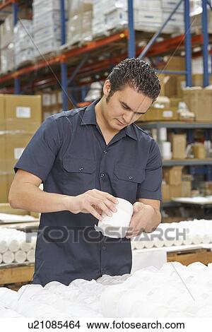Picture - Factory Worker Checking Goods On Production Line. Fotosearch