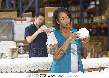 Stock Image - Factory Worker Checking Goods On Production Line. Fotosearch