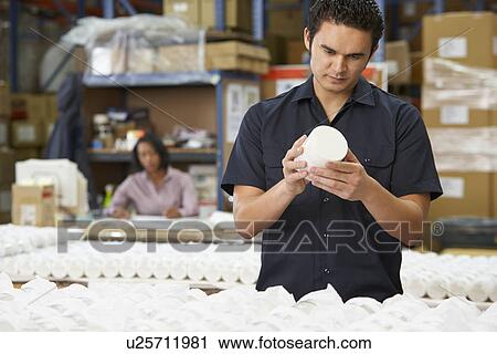 Stock Image - Factory Worker Checking Goods On Production Line. Fotosearch