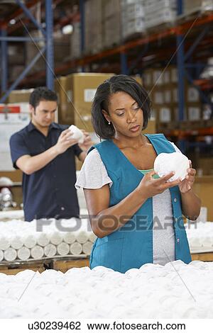 Stock Image - Factory Worker Checking Goods On Production Line. Fotosearch