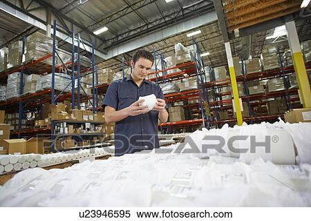 Stock Photography - Factory Worker Checking Goods On Production Line. Fotosearch