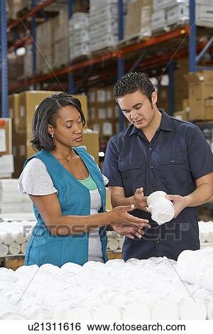 Stock Photograph - Factory Worker Training Colleague On Production Line. Fotosearch