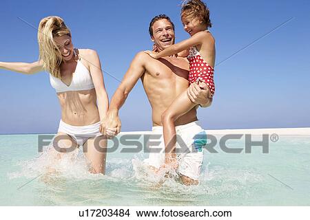 Picture - Family Having Fun In Sea On Beach Holiday. Fotosearch