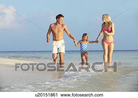 Stock Image - Family Having Fun In Sea On Beach Holiday. Fotosearch