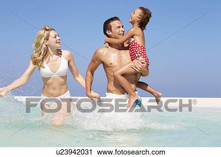 Stock Image - Family Having Fun In Sea On Beach Holiday. Fotosearch