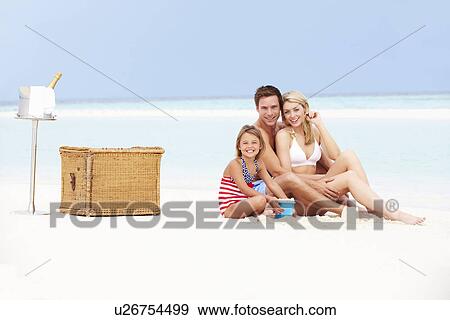 Stock Photo - Family On Beach With Luxury Champagne Picnic. Fotosearch