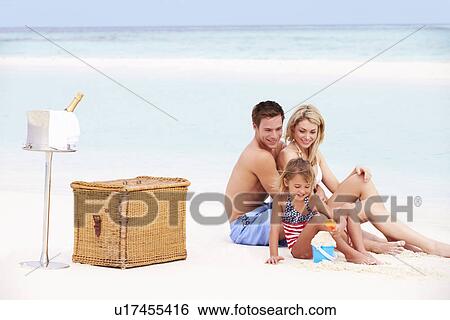 Stock Photograph - Family On Beach With Luxury Champagne Picnic. Fotosearch