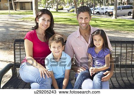 Stock Image - Family Sitting On Park Bench Together. Fotosearch
