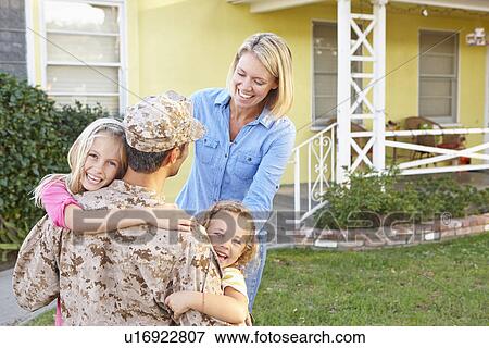 Stock Photo - Family Welcoming Husband Home On Army Leave. Fotosearch