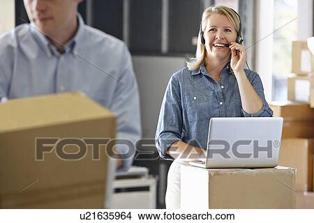 Female Manager Using Headset In Distribution Warehouse View Large Photo Image Picture - Female Manager Using Headset In Distribution Warehouse. Fotosearch