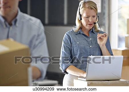 Female Manager Using Headset In Distribution Warehouse View Large Photo Image Stock Photo - Female Manager Using Headset In Distribution Warehouse. Fotosearch