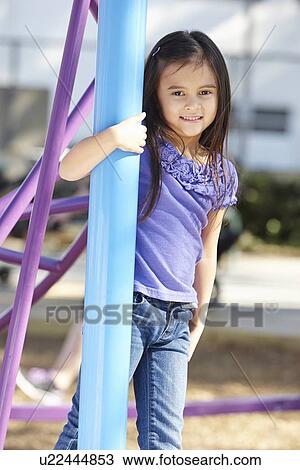 Stock Image - Girl On Climbing Frame In Park. Fotosearch
