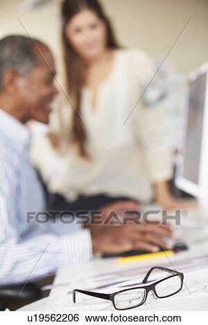 Glasses Resting On Desk In Busy Creative Office View Large Photo Image Stock Photograph - Glasses Resting On Desk In Busy Creative Office. Fotosearch
