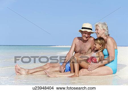 Picture - Grandparents With Granddaughter Enjoying Beach Holiday. Fotosearch