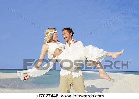 Groom Carrying Bride At Beautiful Beach Wedding View Large Photo Image Stock Photo - Groom Carrying Bride At Beautiful Beach Wedding. Fotosearch