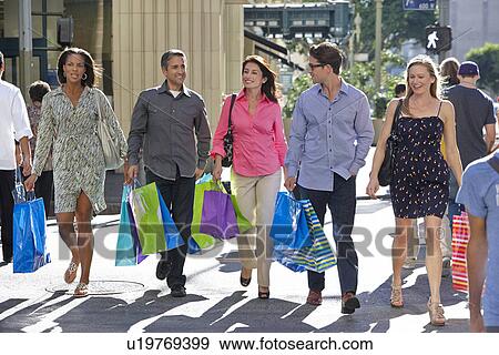Stock Photo - Group Of Friends Carrying Shopping Bags On City Street. Fotosearch