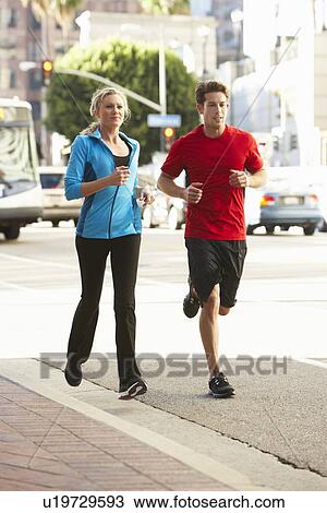 Stock Image - Male And Female Runners On Urban Street. Fotosearch