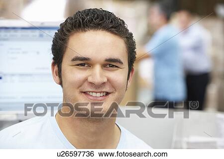 Stock Photograph - Man At Computer Terminal In Distribution Warehouse. Fotosearch